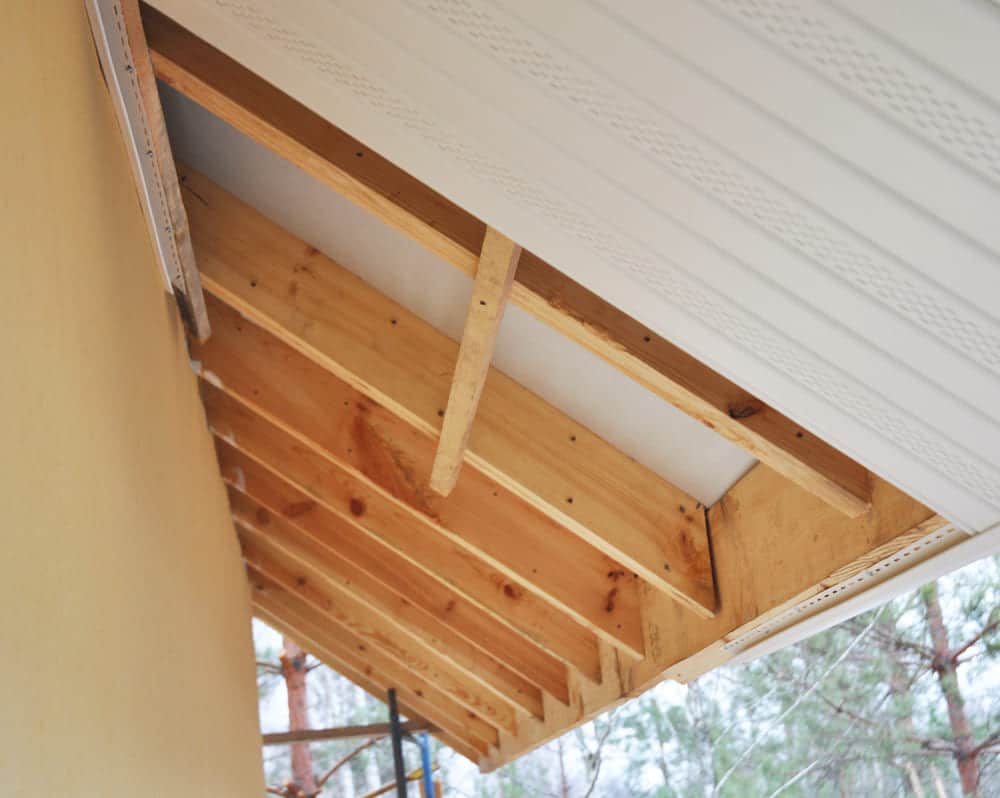 Close up on Roofing Construction. Soffit and Fascia Installation. is Usually Constructed of Vinyl, Wood or Aluminum and is Installed on the Underside of Roof Overhangs and Eaves.